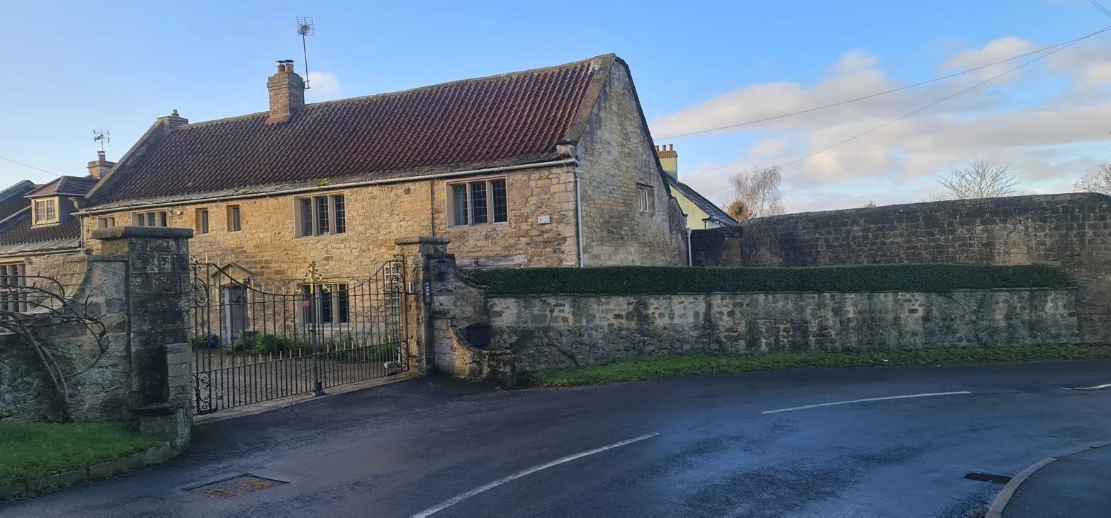 The Old Manor House of Farnham — a 1667 coursed-limestone gentleman's house with red pantile roof and iron gates