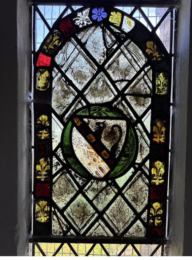 The conserved medieval panel back in its window at St Oswald's, the heraldic lion roundel clearly visible