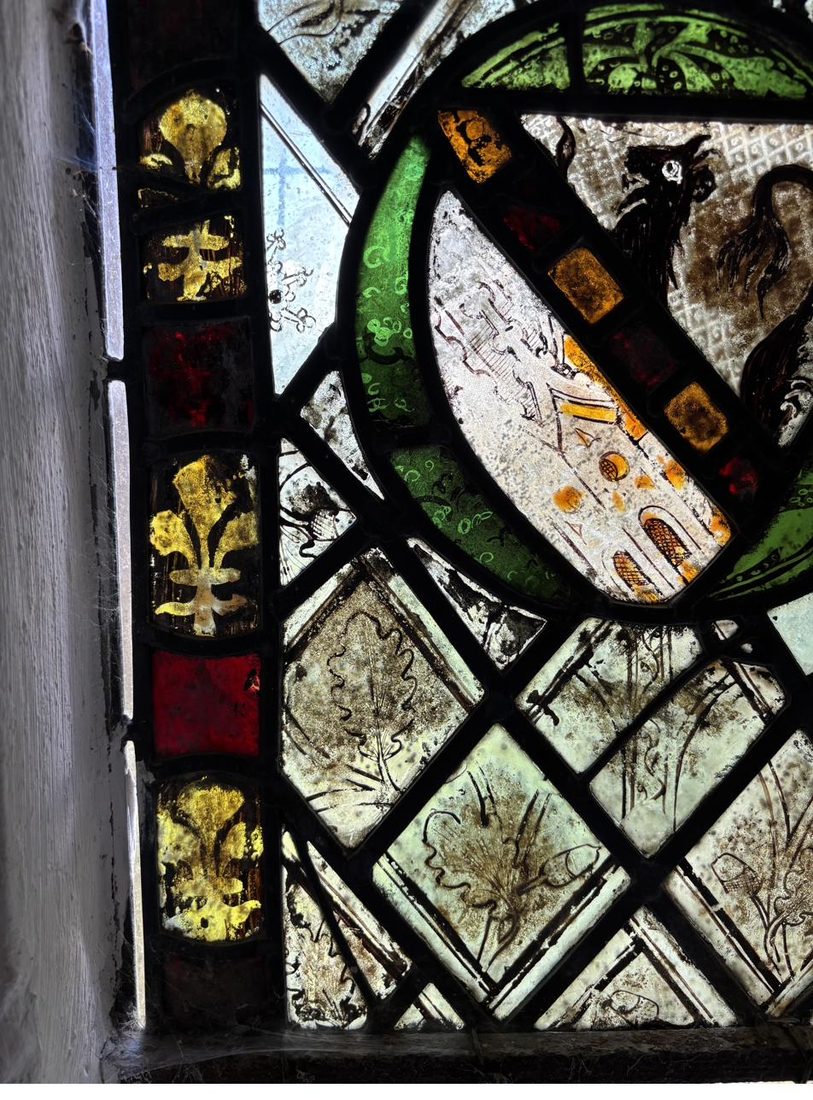 The stained glass panel in its lancet window at St Oswald's before restoration, seen from inside the church