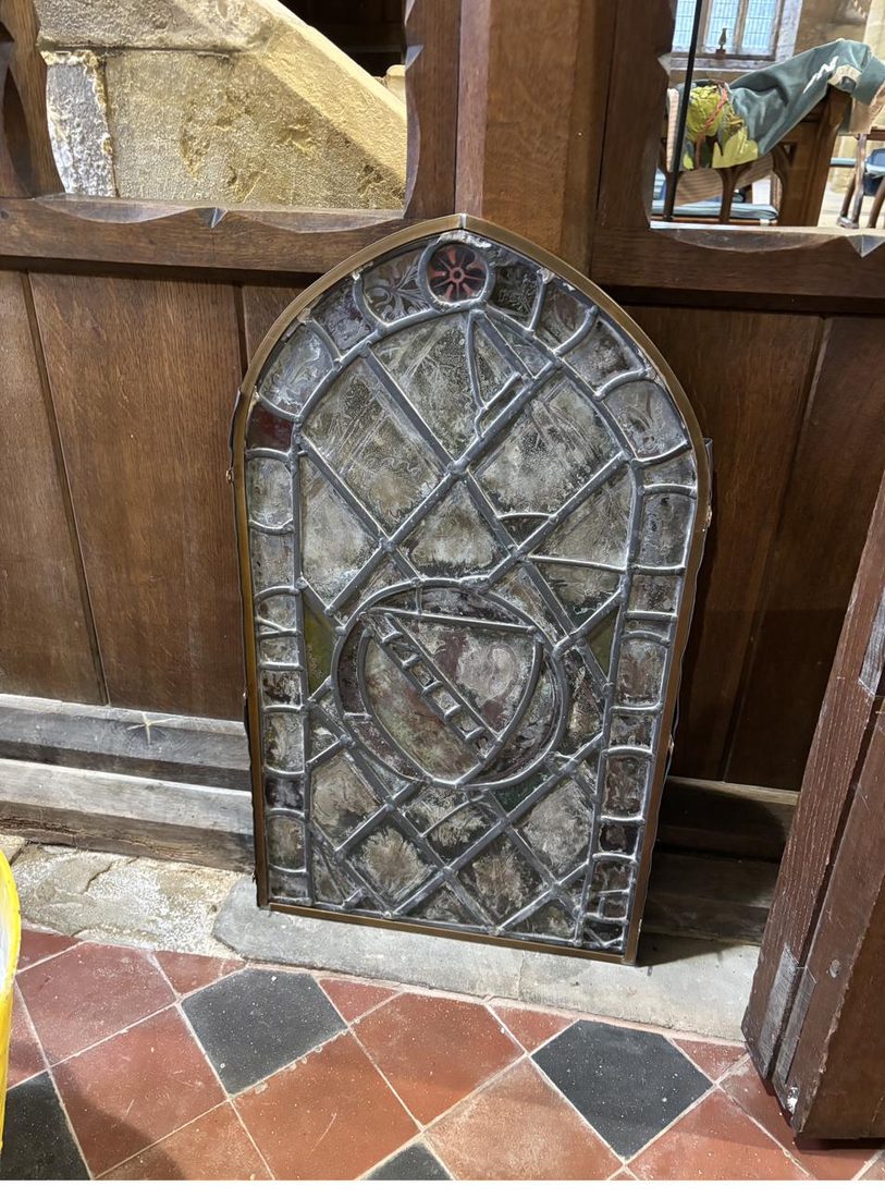 The medieval stained glass panel removed from the window and standing inside St Oswald's Church before being taken to the conservation studio